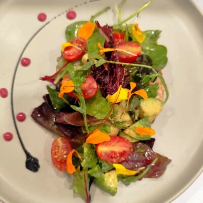 Ensalada de vegetales con tomates y flores comestibles.