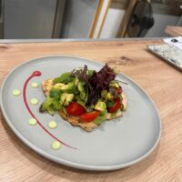 Plato de ensalada con pollo, aguacate y tomates.