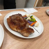 Plato con chuleta y verduras asadas.