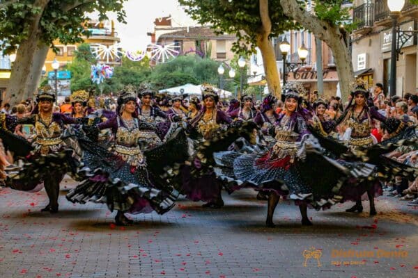 Desfile de mujeres con trajes coloridos en Denia.