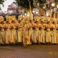Desfile de carnaval en Dénia, personas con disfraces dorados