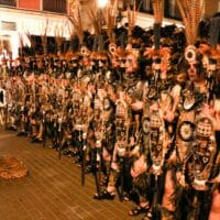 Desfile de personas con trajes tradicionales en una calle.