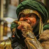 Hombre disfrazado fumando cigarro en carnaval.