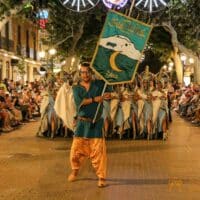 Desfile festivo en Denia con trajes tradicionales.