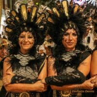 Mujeres con trajes festivos en desfile nocturno