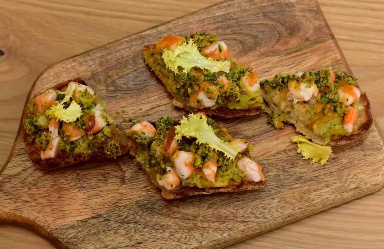 Tostada de camarones y brócoli en tabla de madera
