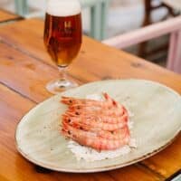 Gambas al ajillo y cerveza sobre mesa