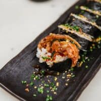 Sushi en plato negro con salsa