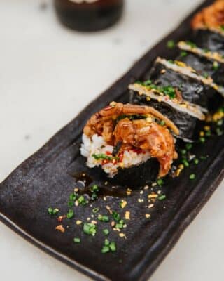 Sushi en plato negro con salsa