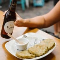Cerveza Turia y plato con aperitivo.