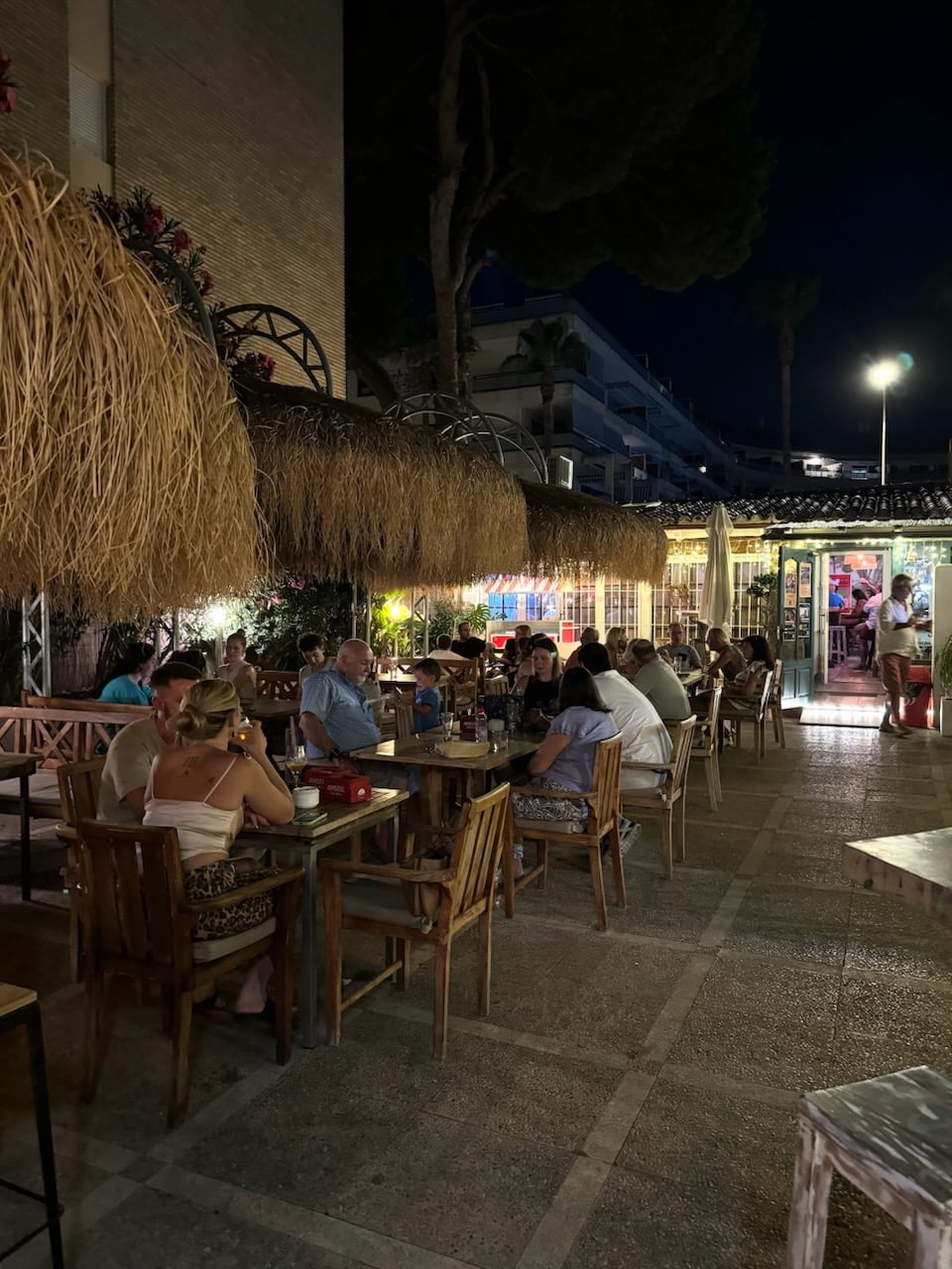 Personas cenando en una terraza por la noche