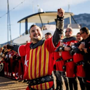 Hombre medieval celebrando con traje y espada.