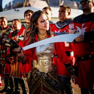 Personas vestidas de guerreros medievales en desfile.