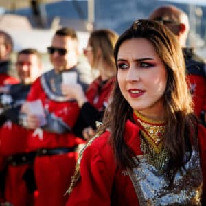 Desfile medieval con personas en trajes históricos rojos