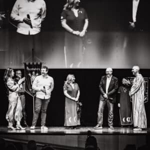 Personas en un escenario, evento en teatro.