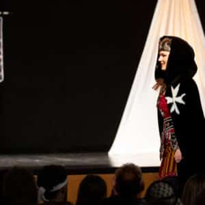 Desfile medieval en festival cultural con banderas.