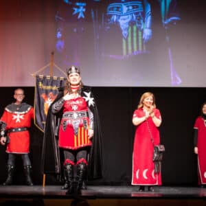Personas vestidas de medieval sobre un escenario.