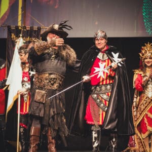 Personas en vestuario medieval en un escenario performando.