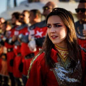 Mujer en festival con traje rojo decorado.