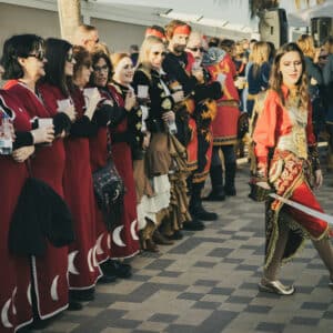 Personas vestidas en traje festivo tradicional en pasacalles.