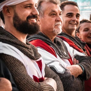 Hombres sonrientes en trajes medievales, cruzados.