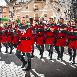 Desfile de hombres con túnicas rojas medievales