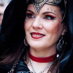 Persona disfrazada con tocado y joyería elaborada.