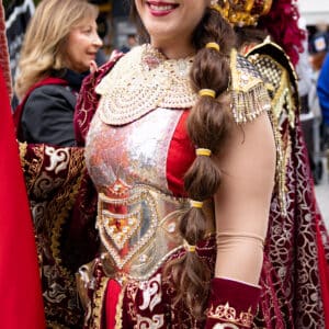 Mujer sonriente en traje medieval, festival al aire libre