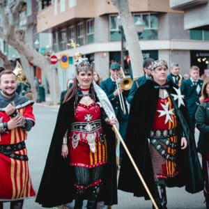 Desfile de personas con trajes medievales en la calle.