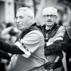 Hombres mayores en desfile medieval con disfraces.