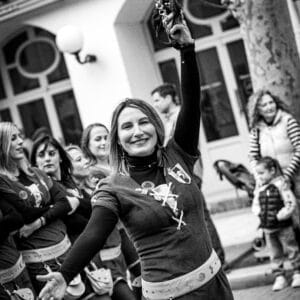 Mujer sonriente desfilando en un evento callejero.