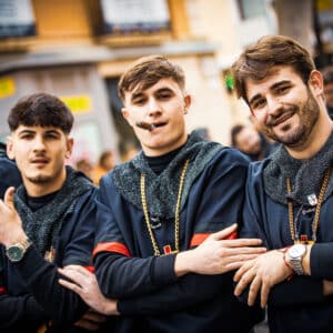 Hombres jóvenes vestidos de negro en fiesta local