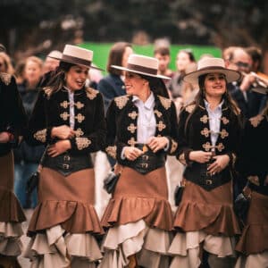 Grupo mujeres con trajes tradicionales y sombreros.