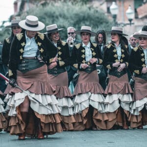 Grupo de mujeres vestidas con trajes tradicionales en desfile.