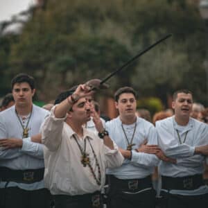 Grupo de hombres desfilando con trajes tradicionales.