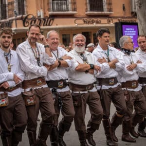 Grupo de hombres en desfile cultural callejero.