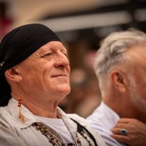 Hombre con pañuelo y pendiente, sonriente