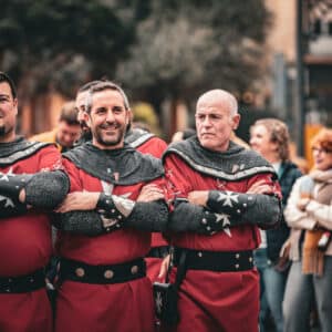 Hombres con trajes medievales en desfile histórico.