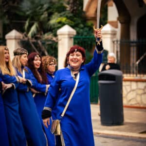 Desfile festivo, mujer con espada, vestida de azul.