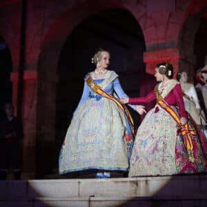 Mujeres con trajes tradicionales en evento cultural nocturno.