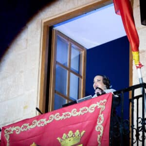 Mujer hablando en balcón decorado con bandera