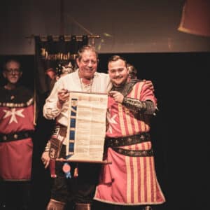 Hombres medievales muestran un pergamino en ceremonia.