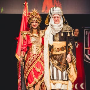 Personajes con trajes tradicionales en evento cultural.