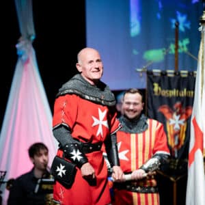 Personas disfrazadas de caballeros medievales en evento.