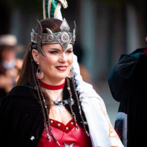 Mujer con traje medieval en desfile festivo.