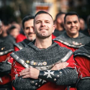 Hombres con trajes medievales en desfile festivo.