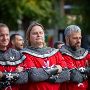 Hombres disfrazados con trajes medievales rojos.