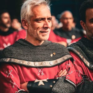 Hombre disfrazado en festival medieval, gesto confiado.