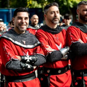 Hombres con trajes medievales rojos en desfile