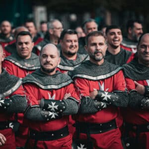 Grupo de hombres con trajes medievales rojos.